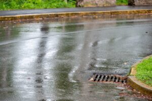 Water rushing down a street into a storm drain