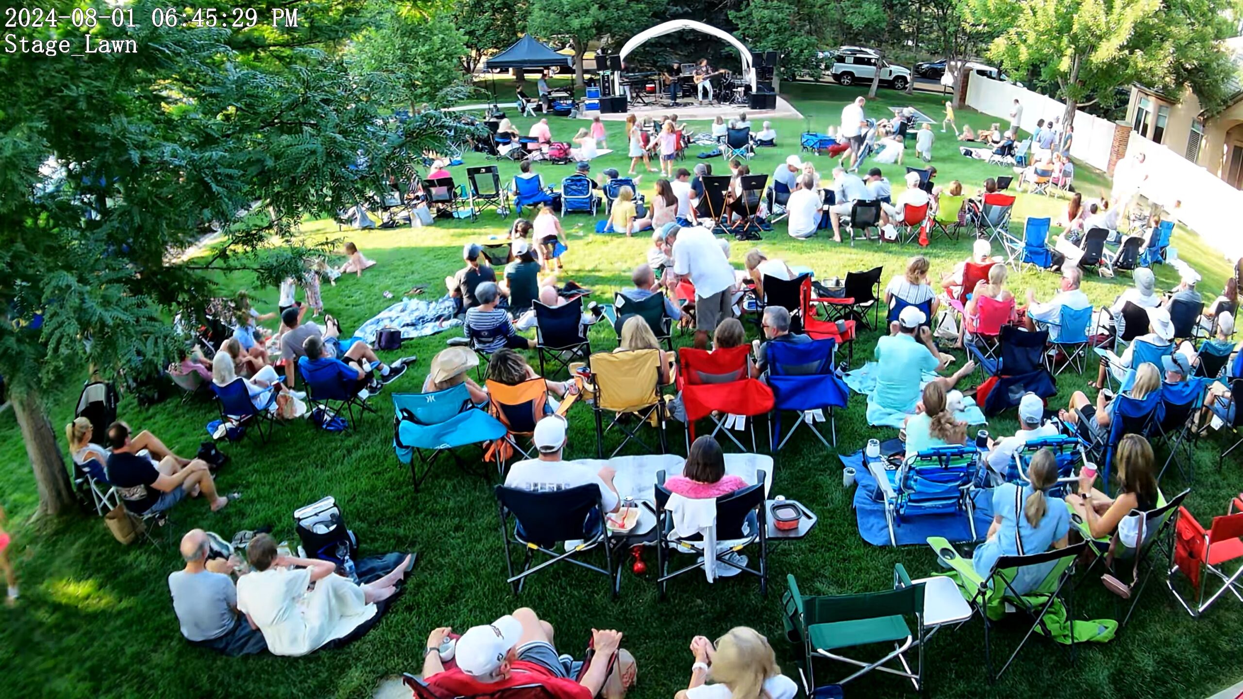 overhead shot of people watching a concert on a lawn