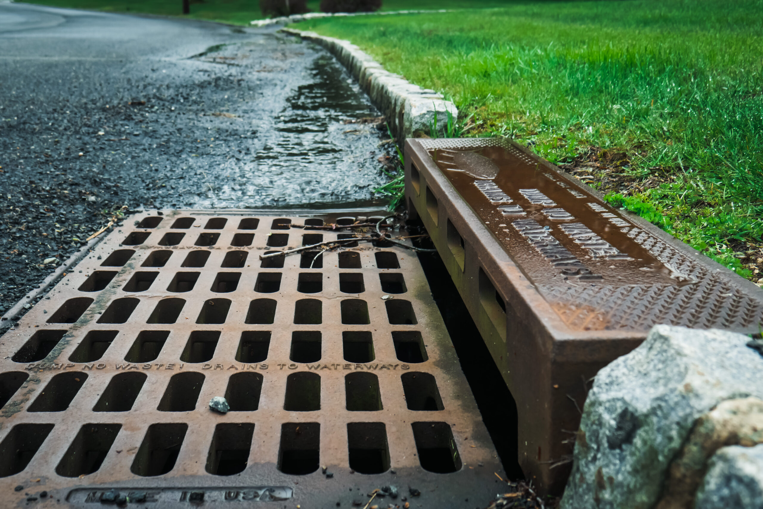 Stormwater drain with water rushing and twigs